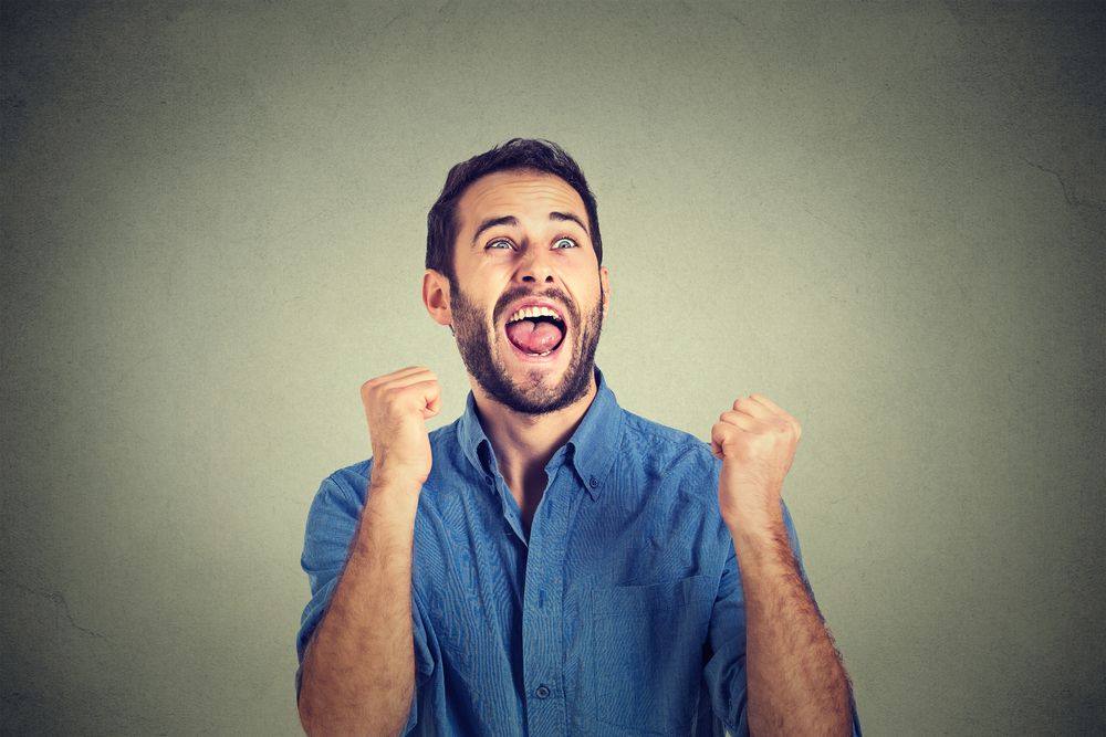 Closeup portrait happy successful student, business man winning, fists pumped celebrating success isolated grey wall background. Positive human emotion facial expression. Life perception, achievement