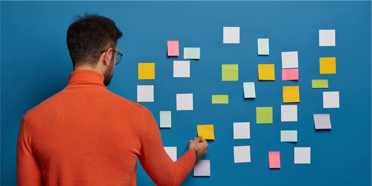 Man brainstorming growth strategy using sticky notes | Botkeeper | How Your Firm Defines CAS Will Determine Your Growth Strategy