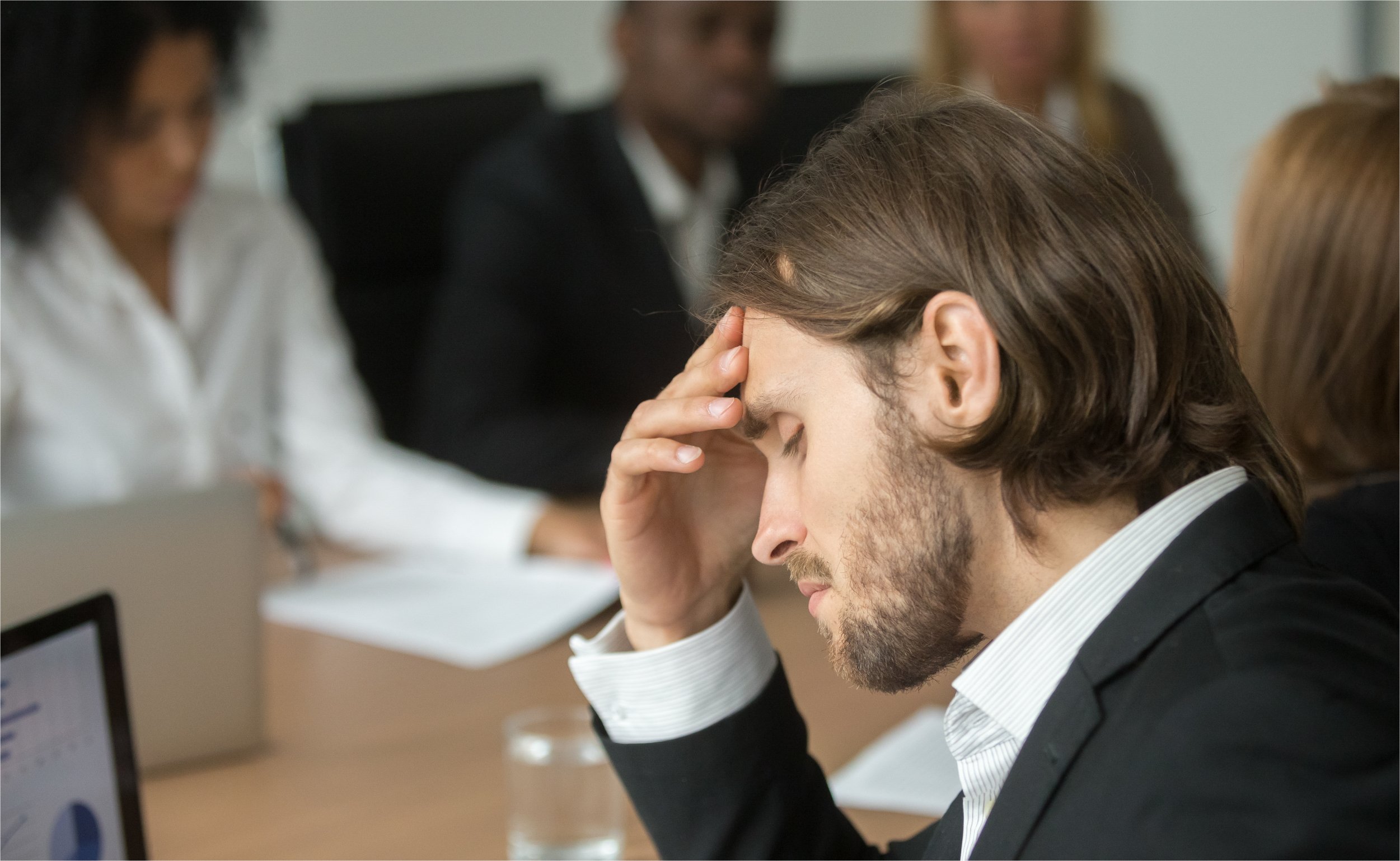 frustrated-tired-businessman-having-strong-headache-diverse-team-meeting | botkeeper