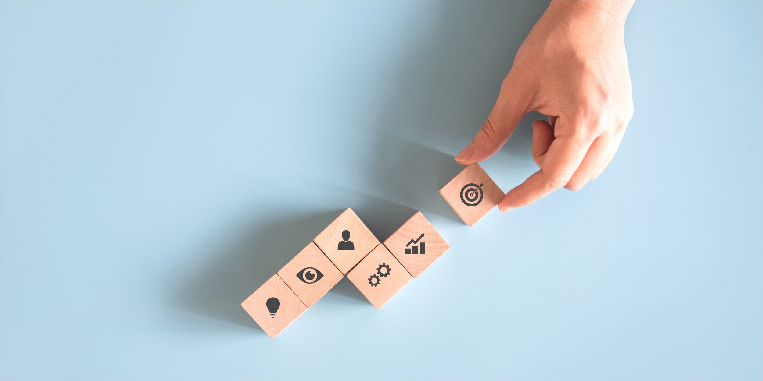 hand-arranging-wood-blocks-with-business-icons-light-blue-background_Blog copy