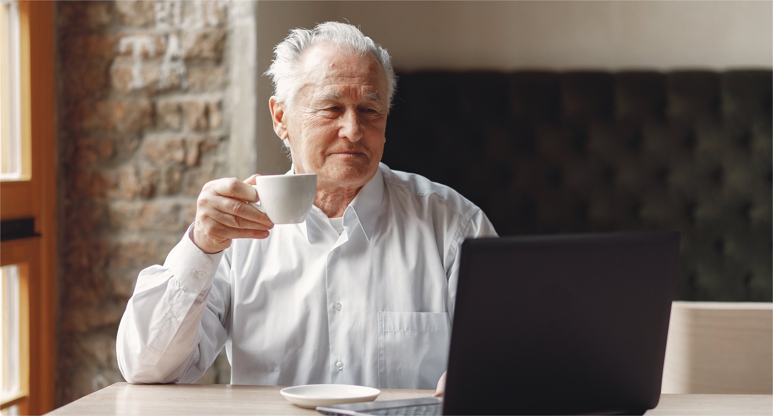 old-man-sitting-table-working-with-laptop | Botkeeper