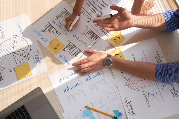 top-view-creative-team-discussing-business-graphs-drawn-marker-pens_NBLOG copy
