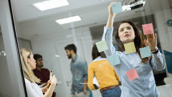young business women discussing in front of a glass wall using post it notes-02-02