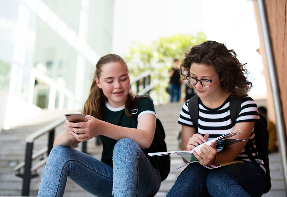 2-female-students-reading-stairs-botkeeper