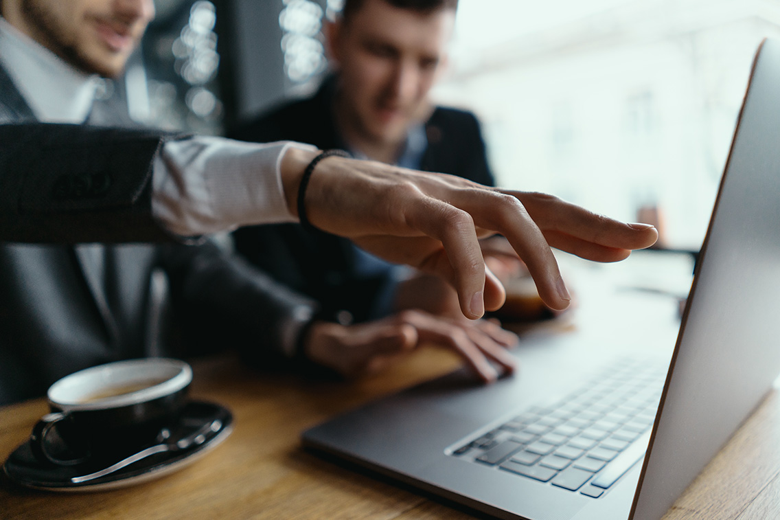 two-businessmen-pointing-laptop-screen-while-discussing-botkeeper