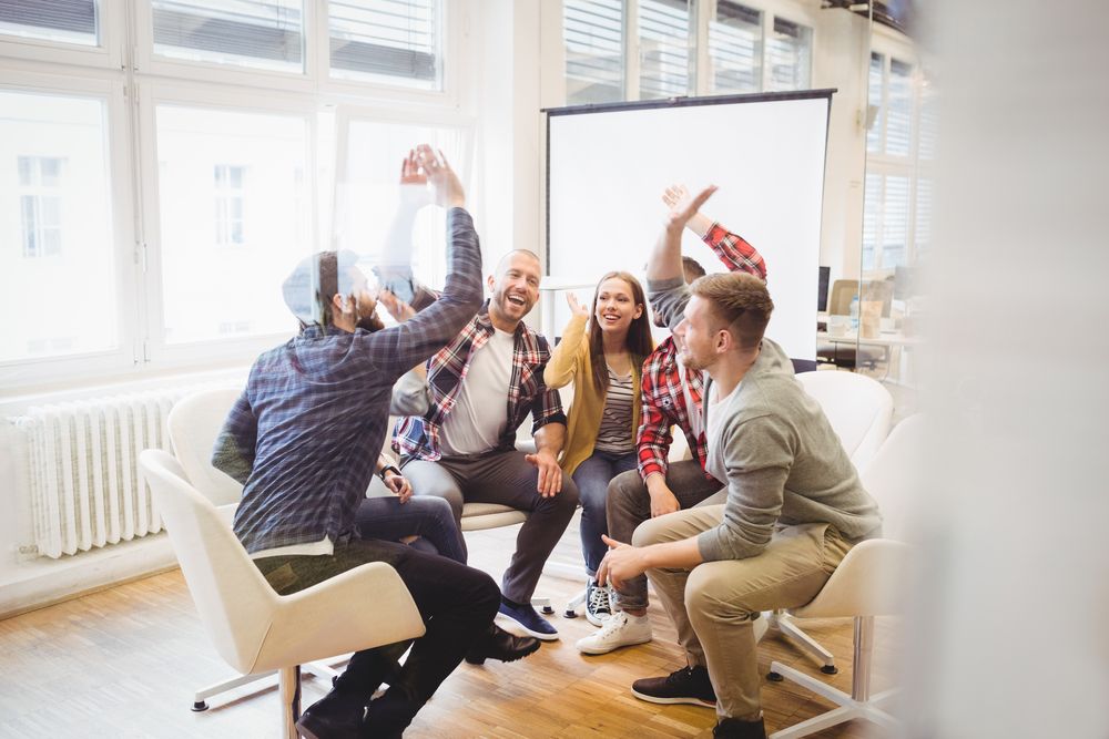 Excited creative business people giving high-five in meeting room at creative office-1