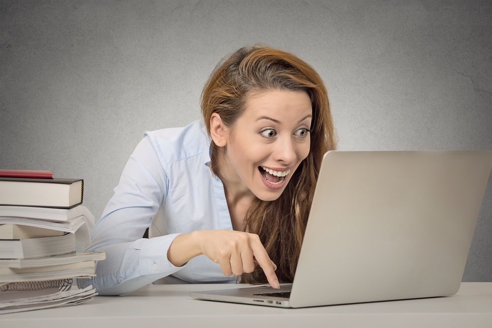 Woman working on computer ready press enter button isolated grey office wall background. Funny funky crazy looking girl excited what she see on laptop screen browsing internet. Face expression emotion