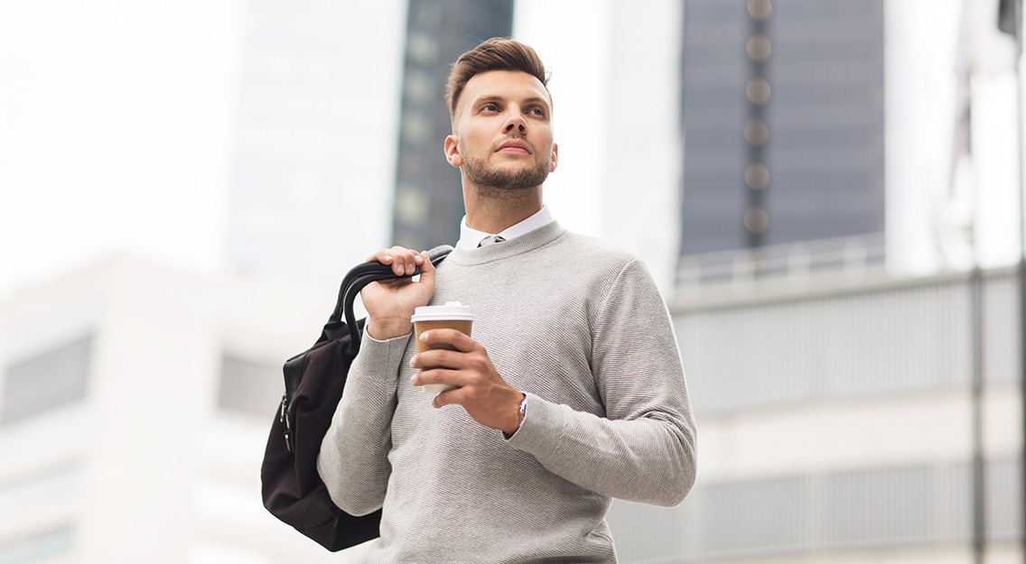 lifestyle-drinks-people-concept-young-man-with-bag-drinking-coffee-from-paper-cup-city