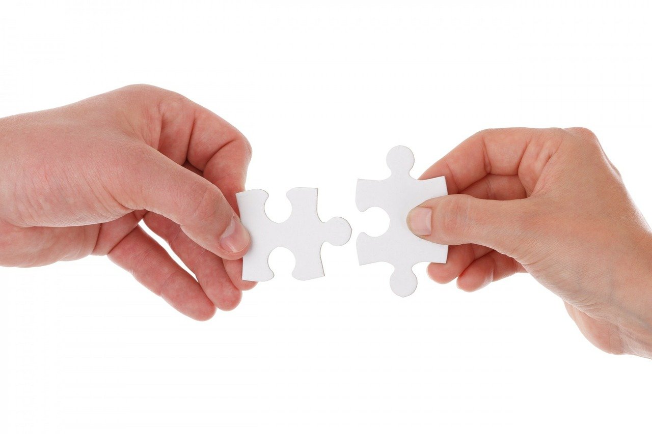 hands connecting puzzle pieces 