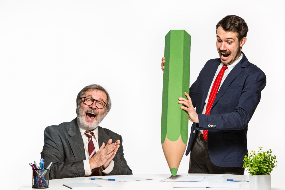 two-colleagues-working-together-office-with-huge-giant-pencil